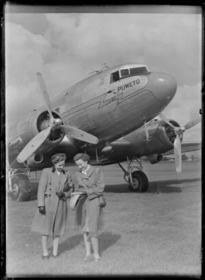 Two women standing in front of the Dakota aircraft Puweto, Milson Aerodrome, Palmerston North