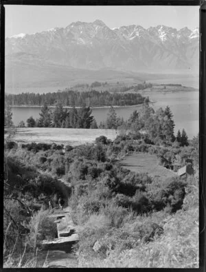 View of section and old foundations amongst the scrub, with Lake Wakatipu and the Remarkables in the background