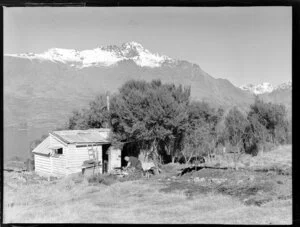 Elderly man sawing beside his shack on the shores of Lake Wakatipu, near Queenstown