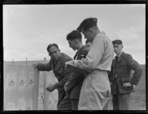 ATC [Air Training Corps] weekend camp, Whenuapai, examining targets on range. Left to right: Flight Sergeant P Te Wai, Cadet Cathy, Captain Menzies