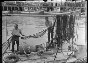 Fishermen mending nets at market wharves, Auckland