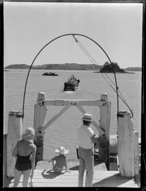 A man, woman and boy watching the launch, Knoxie II leaving Paihia