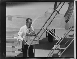 Airline steward F Bennett carrying supplies to a Dakota aircraft
