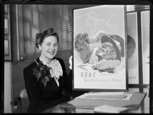 Mary Wootton (Miss New Zealand) holding a BOAC (British Overseas Airways Corporation) poster, at Whites Aviation offices, Auckland