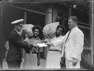 Two Fijian men hold sacks of mail, while the captain and another man exchange a document, Fiji survey flight