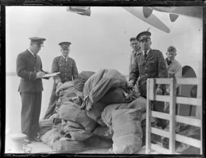 Tasman Empire Airways Ltd staff members loading mail bags onto aircraft