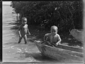 Tongan children, playing at the waters edge, with a canoe, lmperial Airways Ltd