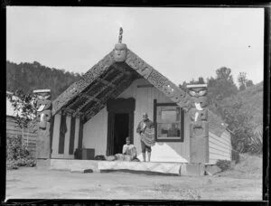 Woman and man outside the Manuhuia meeting house, Lake Rotoiti
