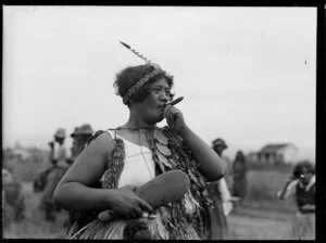 Wahine smoking a cigar, location unidentified