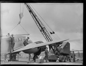 Detaching crane tackle from Cessna aircraft, Kings wharf, Auckland