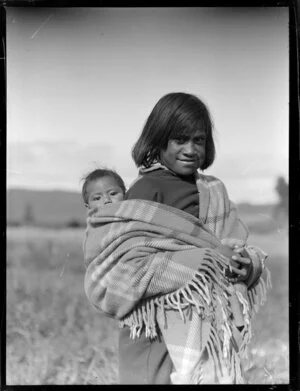 Unidentified Maori child with baby on back wrapped in a blanket