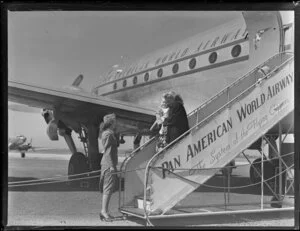 Pan American World Airways passenger arrival, unidentified woman and children greeted by the stewardess