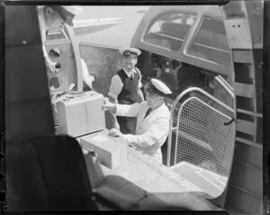 New Zealand National Airways Corporation, unloading freight from a Dakota, Whenuapai Aerodrome, Auckland