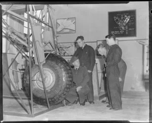 Flight Sergeant J A Hinton instructing air frame mechanics of a De Havilland Mosquito undercarriage to AC2 F E B McFadden, AC2 C F L Banner, and AC2 I D Durney, Hobsonville Technical Training School