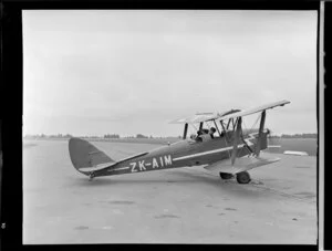 De Havilland Moth biplane ZK-AIM, on tarmac at Christchurch airport with unidentified passengers
