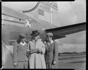 Mr John Wood, Pan American World Airways agent, with flight attendants Miss Pat Meek, left, and Miss Florence Wood, airplane Clipper Westward Ho in background