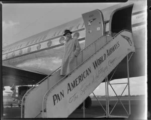 Mr John Wood, Christchurch agent for Pan American World Airways, on gangway beside airplane Clipper Westward Ho
