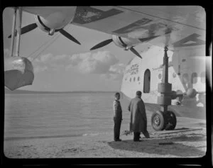 Two unidentified men standing next to Aotearoa aircraft, Mission Bay, Auckland