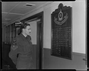 Flight Sergeant Dimmock, British Empire Medal, standing alongside the Honours Board of the E & W School