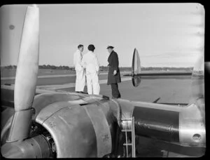 Unidentified group of men standing on the wing of a Lockheed Constellation aircraft, Whenuapai