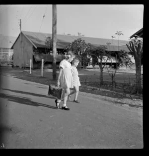 Two schoolchildren walking down a road, Berrimah, Darwin, Australia