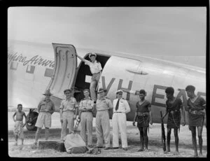 Qantas Empire Airways' line-up from left to right, a local boy, Mr R E Goodson, Master of the government ship, Sirius, [Flight-Lieutenant V Newman], Royal Australian Air Force, Flight-Engineer A Nicol, Sub-Inspector C D Carr, New Guinea Police Force, Qantas Empire Airways, Captain W Horgan-Smith and Mr I Little, purser, (above), and three members of the Buka Island Native Police, Los Negros Airport, Admiralty Islands, Bismarck Archipelago, Papua New Guinea