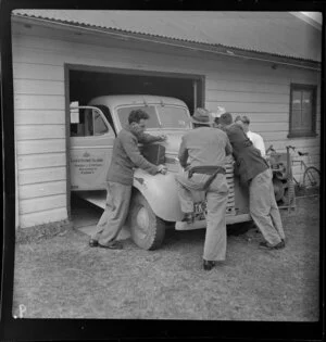 Four unidentified men lean on a Board of Control car, Lord Howe Island, Australia