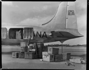 Old Vic Theatre Company luggage is unloaded from an Australian National Airlines aircraft [Constellation?] by unidentified men at Whenuapai Royal New Zealand Air Force base