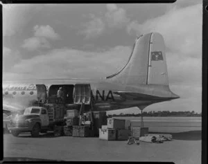 Old Vic Theatre Company luggage is unloaded from an Australian National Airways aircraft [Constellation?] by unidentified men at Whenuapai Royal New Zealand Air Force base