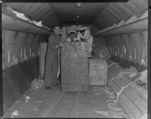 Old Vic Theatre Company luggage is unloaded from an Australian National Airways aircraft [Constellation?] by four unidentified men at Whenuapai Royal New Zealand Airforce base