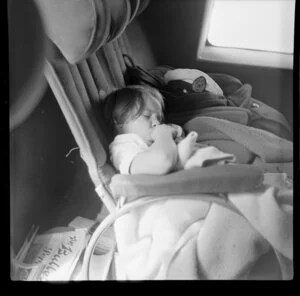 Young child Jennifer Gray, a passenger, sleeping on Qantas Catalina flying boat service from Suva, Fiji, to Sydney, Australia