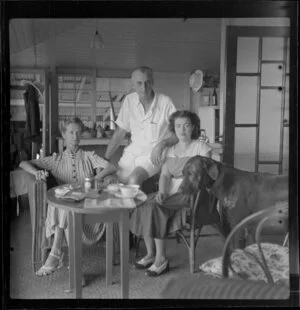 Mr and Mrs C Corbett with an unidentified girl [their daughter?] and a dog inside their house in Fiji