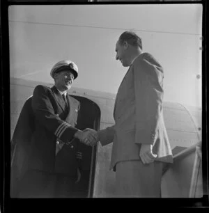 British Overseas Airways Corporation employees P D Hood (Divisional Representative) and an unidentified member of the flight crew shake hands at the door of the Constellation aircraft upon its arrival at Sydney Airport, Mascot, Australia