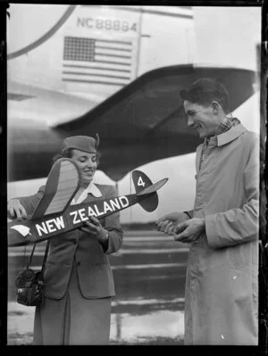 Unidentified people infront of Pan American World Airways holding Wakefield trophy model aeroplane prior to their departure from Whenuapai airport