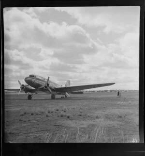 Two unidentified women walking towards Trans Australia Airlines DC3 aeroplane at Griffith airport, Australia