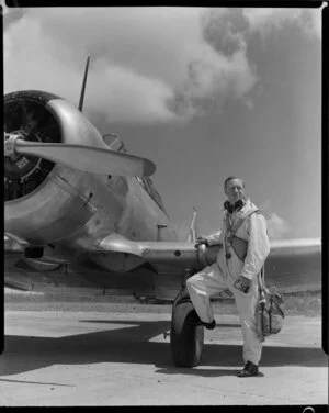 S/L [Squadron Leader?] Keith Patterson, Officer Commanding, Territorial Air Force, with an Harvard aeroplane, [Whenuapai, Auckland?]