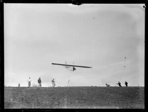 Glider taking off into sky and other members watching, Auckland Gliding Club