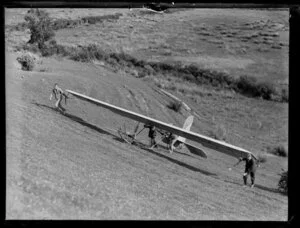 Auckland gliding club members pushing the glider up a hill