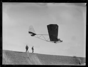 Glider taking off and two members watching from the Auckland Gliding Club