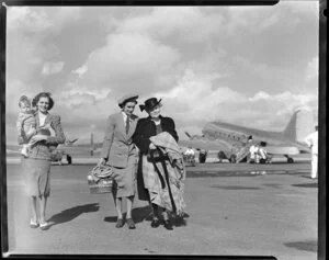 Helen Wood airport hostess helping passengers from the New Zealand National Airways Corporation flight, Whenuapai
