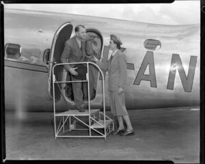 New Zealand National Airways Corporation airport hostess Helen Wood helping Campbell Laurie off an aircraft
