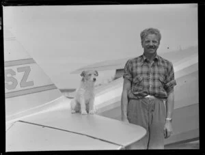 Mr Vic Hunter of Rotorua, with dog, beside his Fairchild Argus aircraft, [Tauranga Aero Club?]