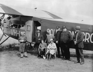 Group including Charles Kingsford-Smith, alongside the Southern Cross aeroplane, Ninety Mile Beach, Far North