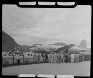 Group behind fence; British Overseas Airways Corporation aircraft Aethra and one other aircraft, Kai Tak airport, Kowloon, Hong Kong