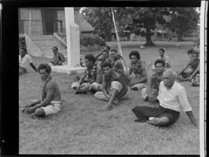 Men sitting on the ground at the meke, Vuda village, Fiji