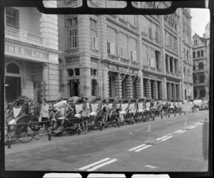 Unidentified men with their rickshaws, outside the Royal Interocean Lines building, Hong Kong