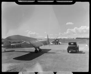 Two aircraft, Auster J1 (ZK-AQE) and de Havilland DH 82A Tiger Moth (ZK-AIF), parked on the tarmac at Aircraft Service, Mangere, Manukau City, Auckland