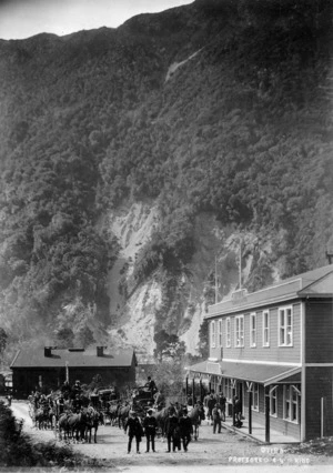A group of horse drawn carriages and people outside the Terminus Hotel, Otira