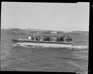 A boat ferries unidentified passengers and Tasman Empire Airways Limited crew to the Short S.45 Solent flying boat, R.M.A Ararangi (ZK-AMM), at Evans Bay, Wellington