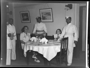 Unidentified woman and girl with waiters in the dining room of the Northern Hotels, Fiji